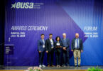 Five individuals stand on a stage during the EUSA Awards Ceremony in Salerno, Italy, on July 19, 2026, with one person holding an award plaque.