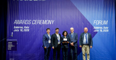 Five individuals stand on a stage during the EUSA Awards Ceremony in Salerno, Italy, on July 19, 2026, with one person holding an award plaque.