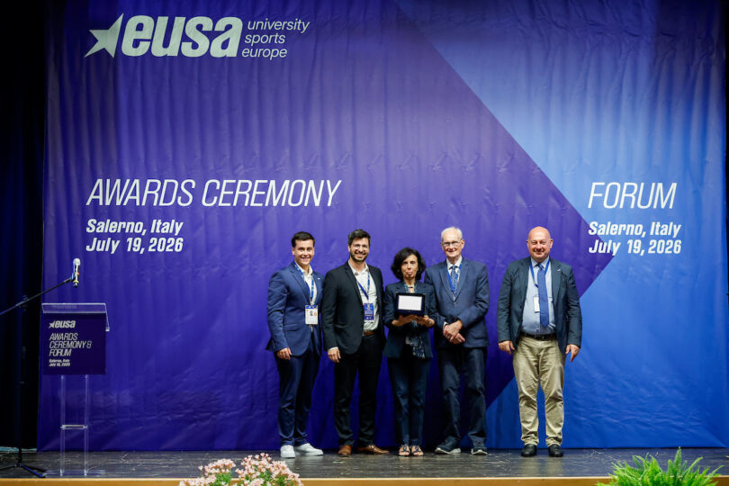 Five individuals stand on a stage during the EUSA Awards Ceremony in Salerno, Italy, on July 19, 2026, with one person holding an award plaque.
